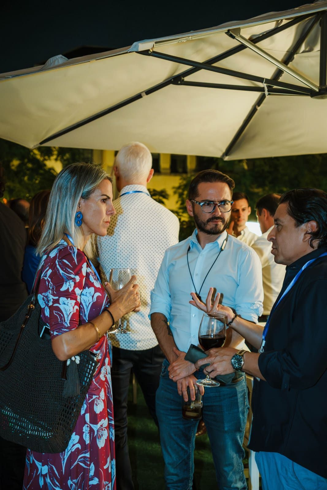 Tres emprendedores en plena conversación con una copa de vino en la mano