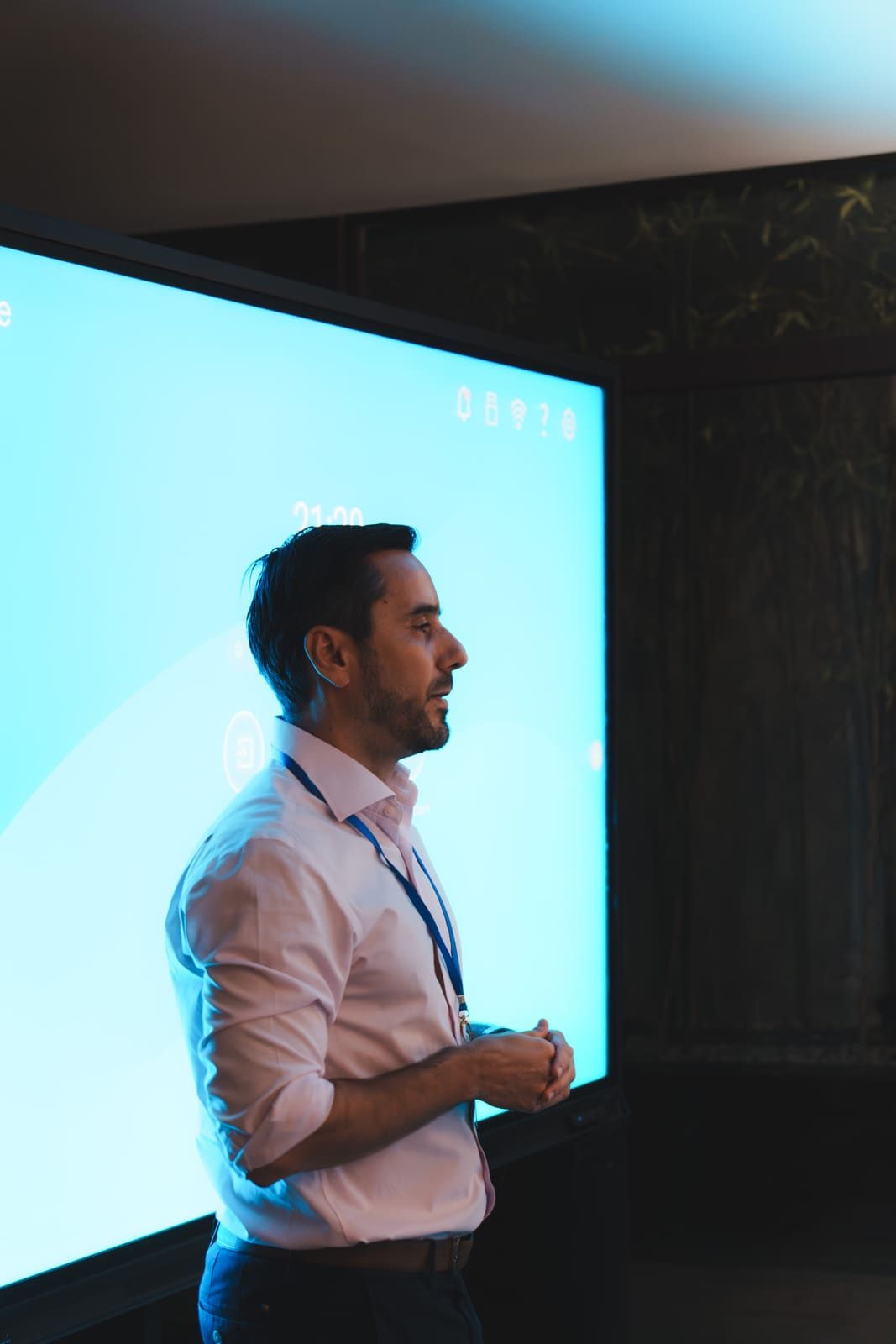 Javier Rodellar, de perfil, hablando frente a la pantalla azul de la sala